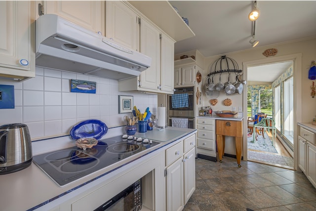 463 Seawall Rd, Southwest Harbor, ME 04679 - kitchen featuring under cabinet range hood, black electric stovetop, backsplash, white cabinets, and crown molding