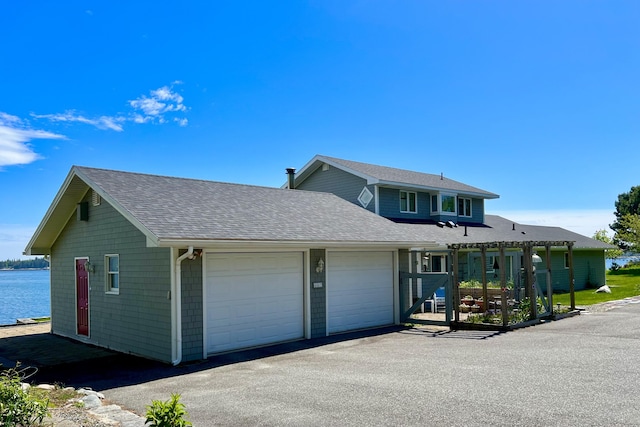 463 Seawall Rd, Southwest Harbor, ME 04679 - view of front of property with an attached garage, roof with shingles, asphalt driveway, and a water view