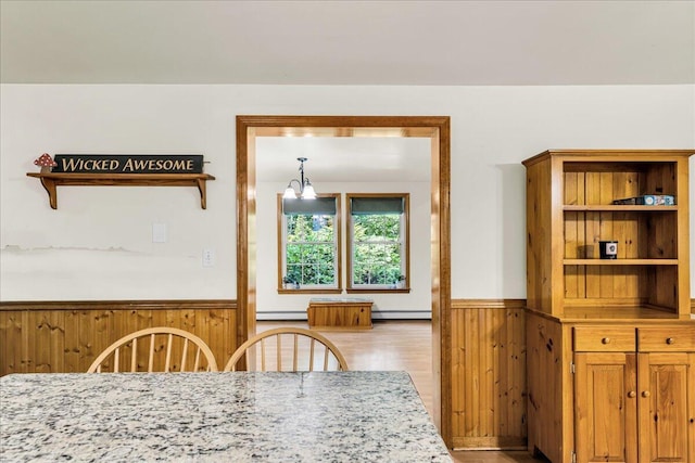 21 Heritage Ln, Orland, ME 04472 - dining space with a wainscoted wall, wood walls, baseboard heating, a chandelier, and wood finished floors