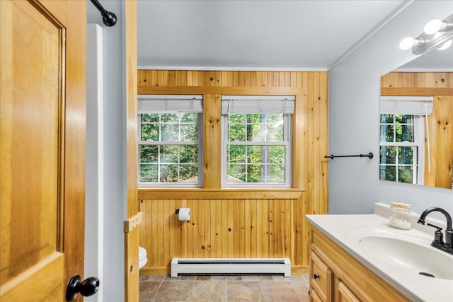 21 Heritage Ln, Orland, ME 04472 - bathroom featuring a baseboard heating unit, wooden walls, healthy amount of natural light, vanity, and crown molding