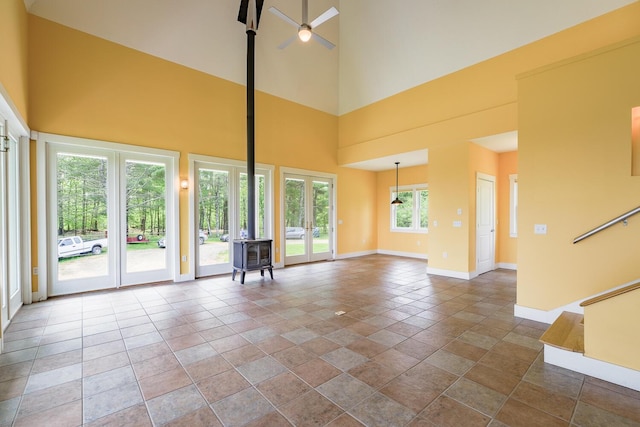 60 Cobb Rd, Belfast, ME 04915 - unfurnished living room with a wood stove, a high ceiling, and baseboards
