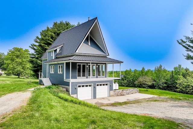 60 Cobb Rd, Belfast, ME 04915 - view of front of house with a front lawn, metal roof, a garage, driveway, and a standing seam roof