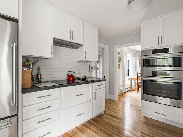 2593 Bristol Rd, Bristol, ME 04554 - kitchen featuring appliances with stainless steel finishes, tasteful backsplash, under cabinet range hood, white cabinets, and light wood-style flooring