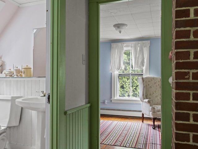 2593 Bristol Rd, Bristol, ME 04554 - bathroom with a baseboard heating unit, wood finished floors, and a wainscoted wall