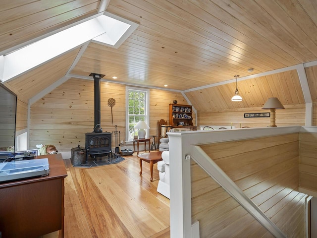 2593 Bristol Rd, Bristol, ME 04554 - living room with wooden walls, lofted ceiling, a wood stove, a skylight, and wood finished floors
