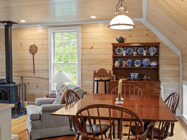 2593 Bristol Rd, Bristol, ME 04554 - dining area with a wood stove, wood walls, wooden ceiling, light wood-style floors, and vaulted ceiling