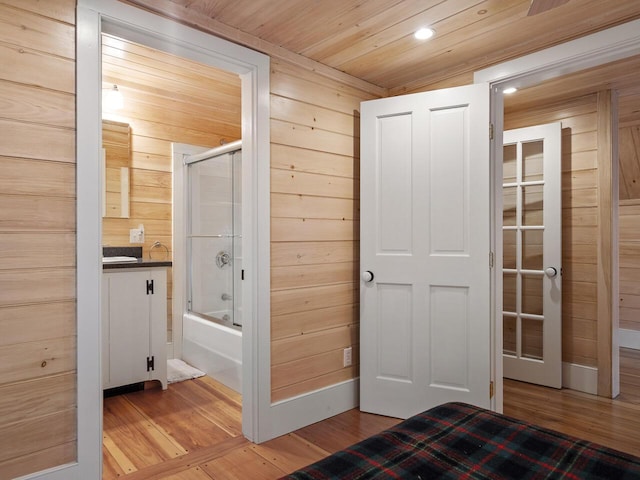2593 Bristol Rd, Bristol, ME 04554 - bathroom featuring wood finished floors, vanity, wood walls, enclosed tub / shower combo, and recessed lighting
