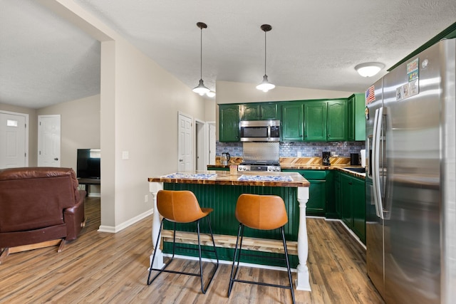 7 Bobcat Ln Unit 7, Berwick, ME 03901 - kitchen with green cabinetry, appliances with stainless steel finishes, vaulted ceiling, backsplash, and light wood-style flooring