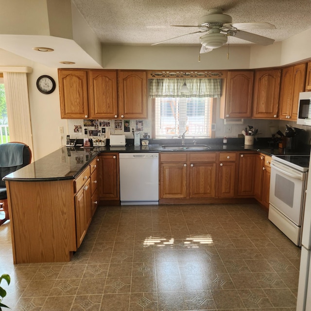116 Main Rd, Passadumkeag, ME 04475 - kitchen with white appliances, a sink, a peninsula, brown cabinetry, and a textured ceiling