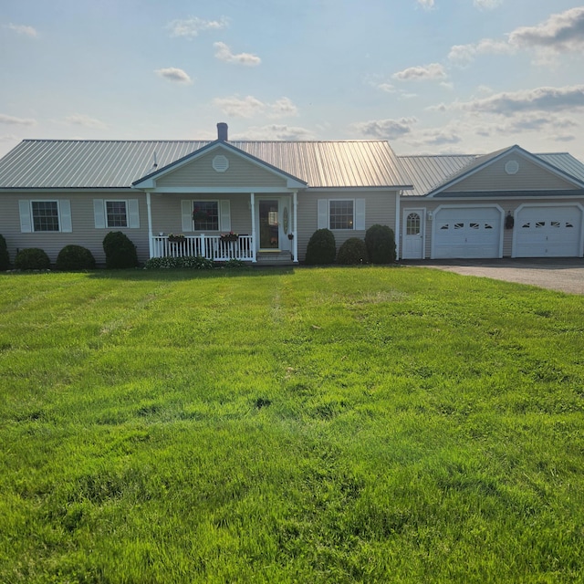 116 Main Rd, Passadumkeag, ME 04475 - view of front of property featuring a porch, a front yard, an attached garage, driveway, and metal roof