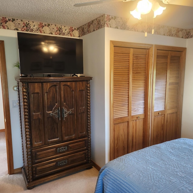 116 Main Rd, Passadumkeag, ME 04475 - bedroom featuring light carpet, two closets, a textured ceiling, baseboards, and ceiling fan