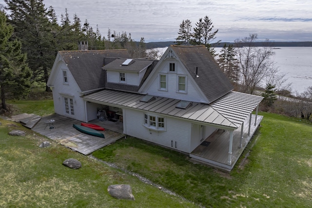 55 Ferry Rd, Swans Island, ME 04685 - back of house with a standing seam roof, a deck with water view, metal roof, a yard, and roof with shingles
