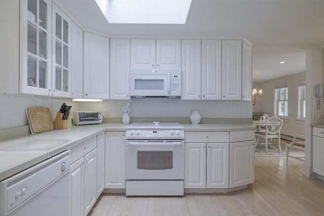 55 Ferry Rd, Swans Island, ME 04685 - kitchen with white appliances, white cabinetry, light wood finished floors, a skylight, and recessed lighting