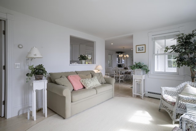 55 Ferry Rd, Swans Island, ME 04685 - living area with a baseboard heating unit, light wood-style flooring, and a chandelier
