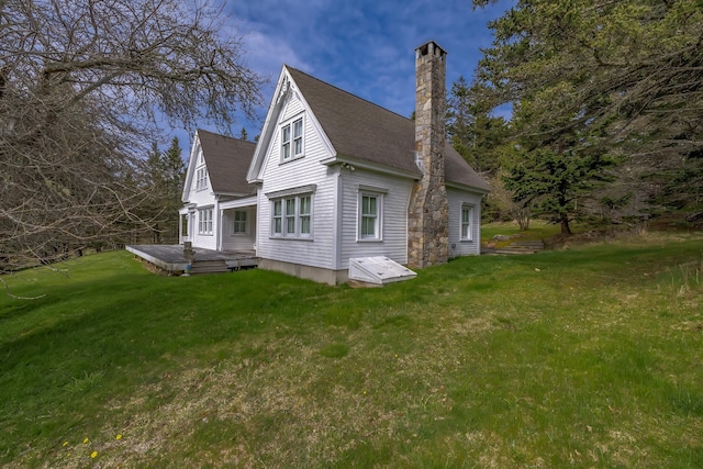 55 Ferry Rd, Swans Island, ME 04685 - view of property exterior with a chimney, a deck, a lawn, and a shingled roof