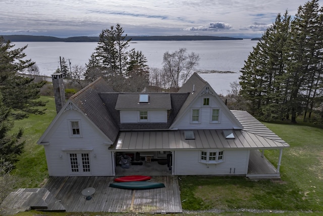 55 Ferry Rd, Swans Island, ME 04685 - back of property with a standing seam roof, metal roof, a deck with water view, a shingled roof, and a yard