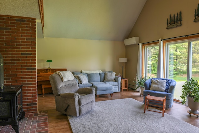 178 Clinton Ave, Winslow, ME 04901 - living room featuring a wood stove, wood finished floors, a wall mounted AC, and high vaulted ceiling