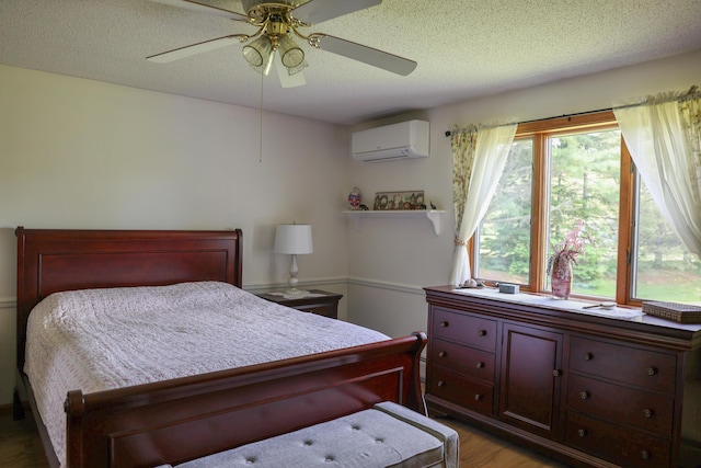 178 Clinton Ave, Winslow, ME 04901 - bedroom with a wall unit AC, wood finished floors, a textured ceiling, and ceiling fan
