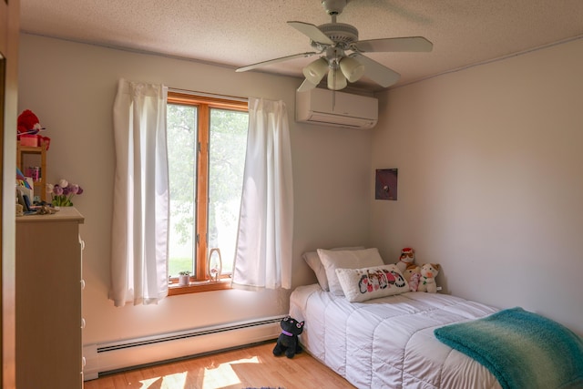 178 Clinton Ave, Winslow, ME 04901 - bedroom featuring baseboard heating, an AC wall unit, wood finished floors, a textured ceiling, and ceiling fan