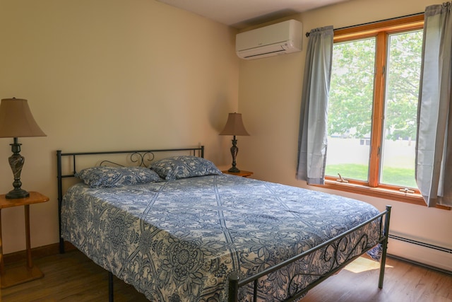 178 Clinton Ave, Winslow, ME 04901 - bedroom with a wall mounted AC, wood finished floors, and a baseboard heating unit