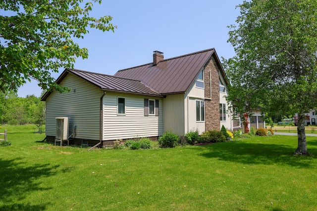 178 Clinton Ave, Winslow, ME 04901 - view of side of property with a standing seam roof, a chimney, a lawn, and metal roof