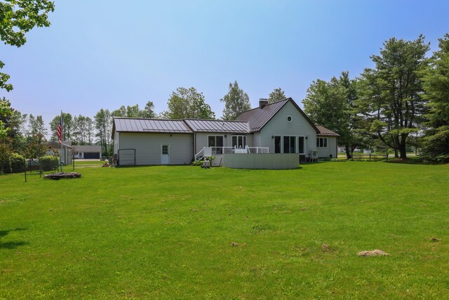 178 Clinton Ave, Winslow, ME 04901 - rear view of house with a yard, a chimney, metal roof, a standing seam roof, and a wooden deck