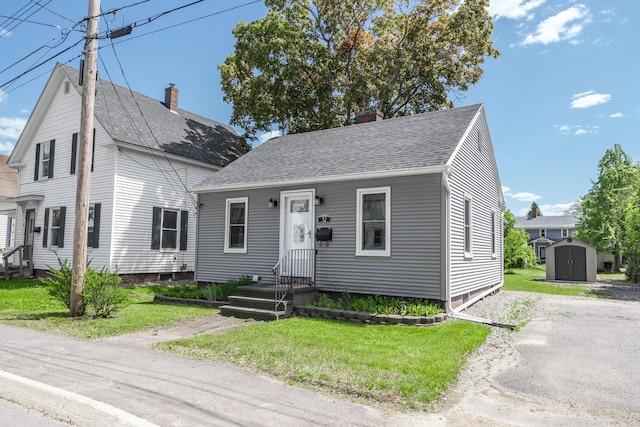32 Carroll St, Old Town, ME 04468 - view of front of house featuring a chimney, a front yard, and a shingled roof