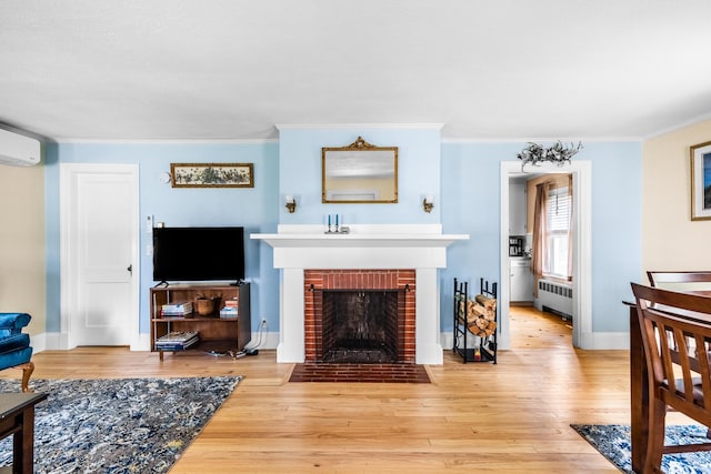 32 Carroll St, Old Town, ME 04468 - living room with radiator heating unit, a brick fireplace, wood-type flooring, crown molding, and baseboards