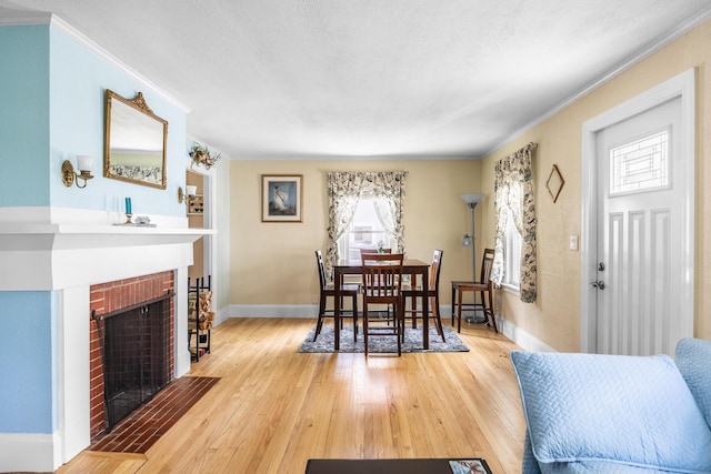 32 Carroll St, Old Town, ME 04468 - dining area with a fireplace, ornamental molding, light wood-style floors, and baseboards