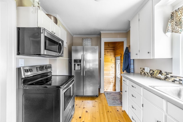 32 Carroll St, Old Town, ME 04468 - kitchen featuring stainless steel appliances, light countertops, light wood-type flooring, white cabinets, and crown molding