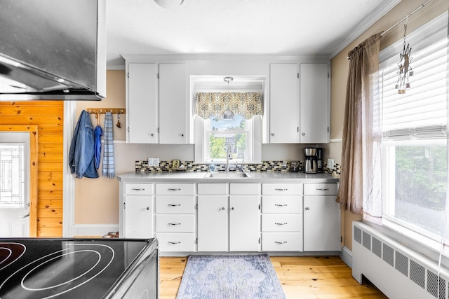 32 Carroll St, Old Town, ME 04468 - kitchen with radiator heating unit, a sink, electric range, and light wood-style floors
