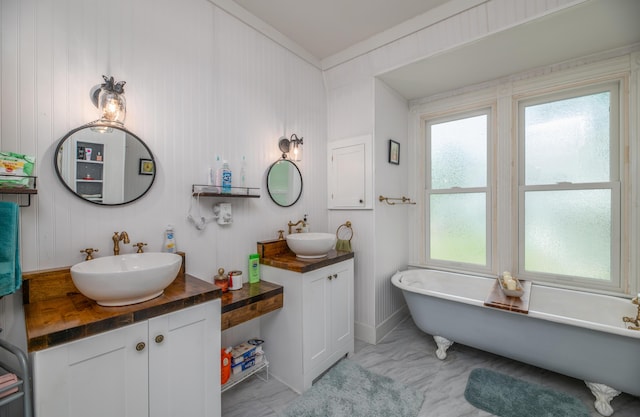 29 Zions Hill Rd, Dexter, ME 04930 - bathroom featuring two vanities, a soaking tub, crown molding, and marble finish flooring