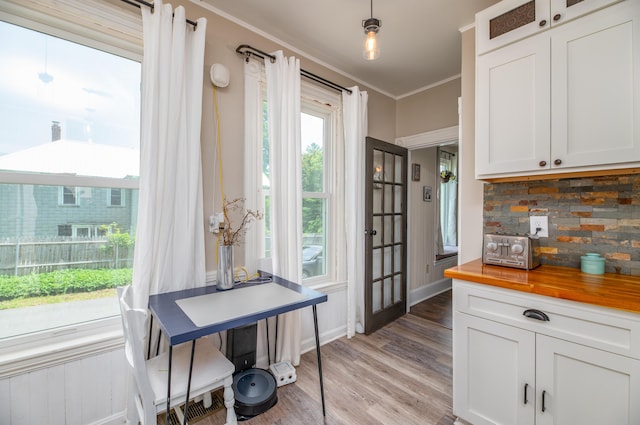 29 Zions Hill Rd, Dexter, ME 04930 - kitchen with butcher block counters, backsplash, light wood-style floors, white cabinets, and ornamental molding