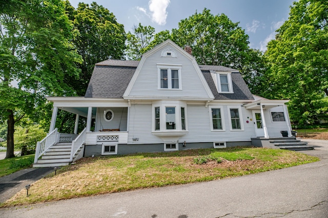 29 Zions Hill Rd, Dexter, ME 04930 - colonial inspired home with a porch, a chimney, roof with shingles, a front yard, and a gambrel roof
