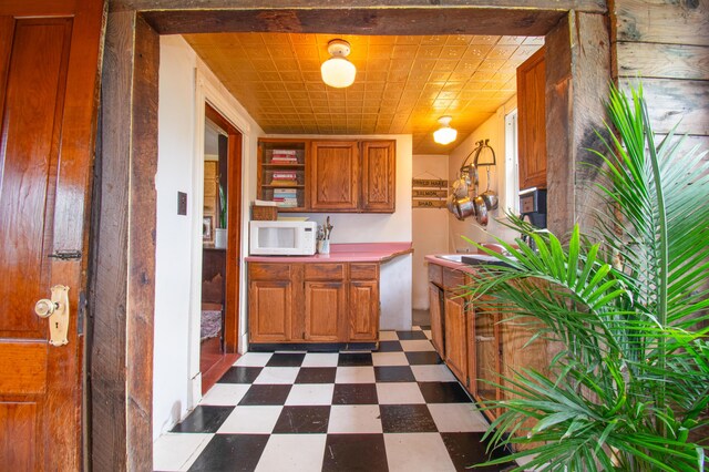 511 Main Rd, Phippsburg, ME 04562 - kitchen with dark floors, white microwave, brown cabinetry, and open shelves