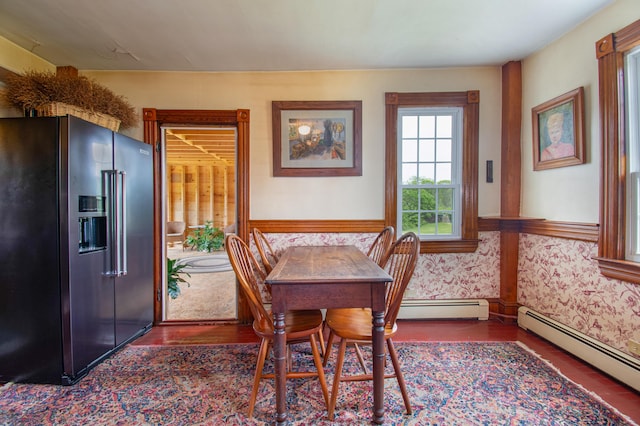 511 Main Rd, Phippsburg, ME 04562 - dining room featuring a baseboard heating unit, wood finished floors, wallpapered walls, and wainscoting