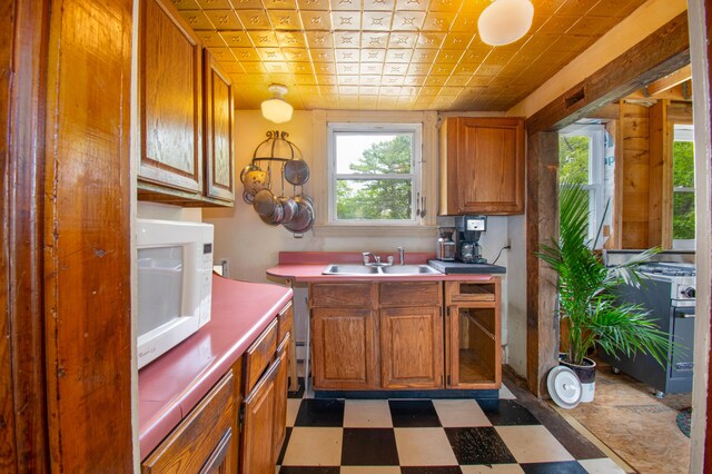 511 Main Rd, Phippsburg, ME 04562 - kitchen with white microwave, tile patterned floors, brown cabinetry, and an ornate ceiling