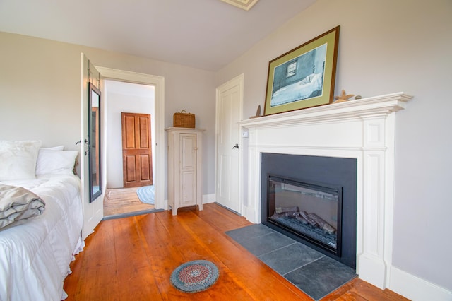 511 Main Rd, Phippsburg, ME 04562 - bedroom with wood finished floors and a fireplace with flush hearth