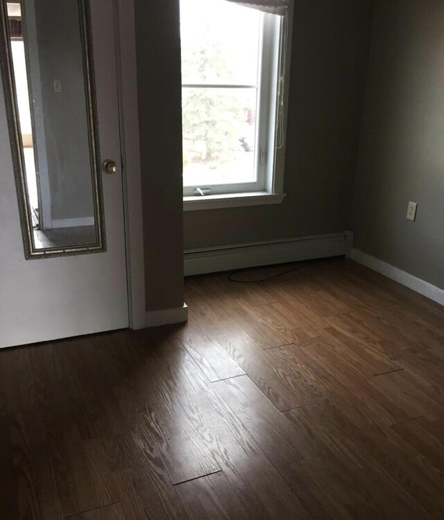 76 E Main St, Fort Kent, ME 04743 - spare room featuring baseboard heating, wood finished floors, and baseboards