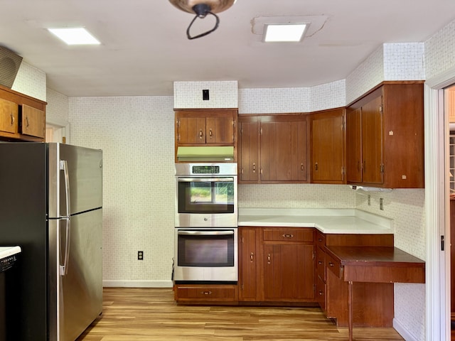 54 Pine Ledge Rd, Bangor, ME 04401 - kitchen with stainless steel appliances, wallpapered walls, light wood-type flooring, and brown cabinets