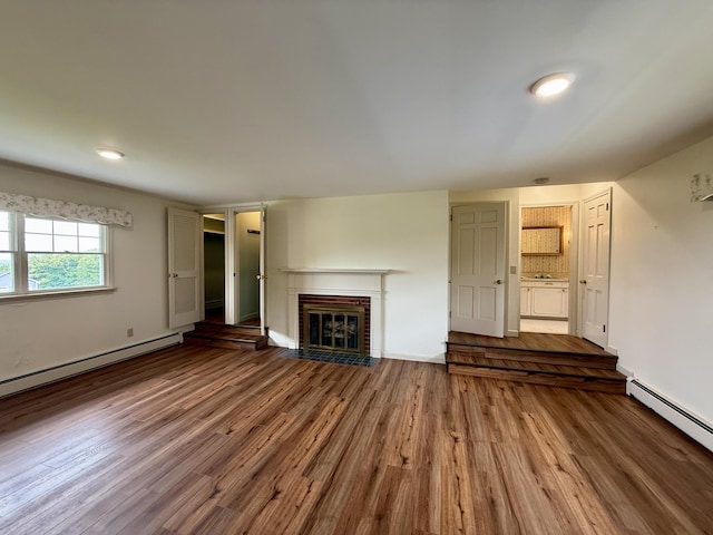 54 Pine Ledge Rd, Bangor, ME 04401 - unfurnished living room with a baseboard heating unit, a brick fireplace, wood finished floors, a baseboard radiator, and recessed lighting