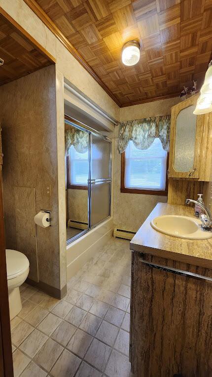 177 Ohio St, Millinocket, ME 04462 - full bathroom featuring an ornate ceiling, a baseboard heating unit, vanity, a shower with shower door, and tile patterned flooring