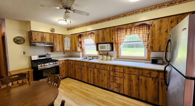 177 Ohio St, Millinocket, ME 04462 - kitchen with stainless steel appliances, range hood, brown cabinets, and light countertops