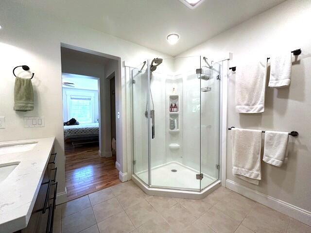 453 Canton Rd, Livermore, ME 04253 - bathroom featuring a shower stall, tile patterned floors, double vanity, and baseboards