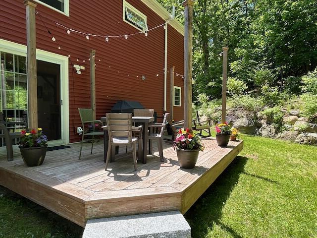 453 Canton Rd, Livermore, ME 04253 - wooden deck with outdoor dining space, area for grilling, and a lawn