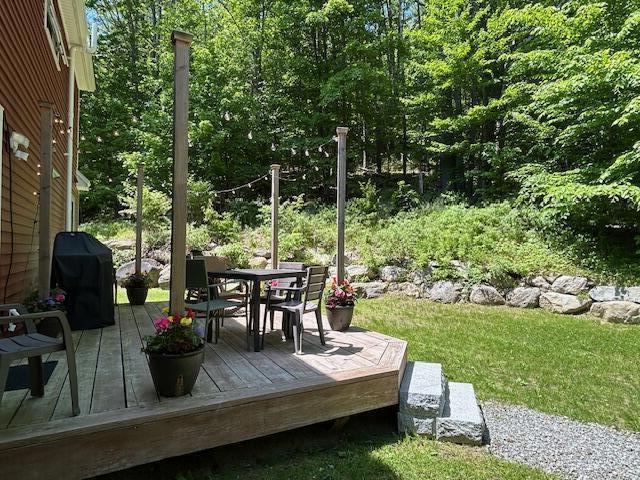 453 Canton Rd, Livermore, ME 04253 - wooden terrace with outdoor dining area and grilling area