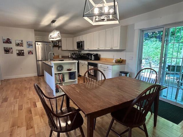 453 Canton Rd, Livermore, ME 04253 - dining room featuring light wood-type flooring, baseboards, and a chandelier
