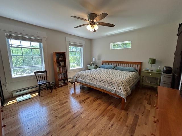453 Canton Rd, Livermore, ME 04253 - bedroom featuring wood finished floors, a baseboard radiator, and ceiling fan
