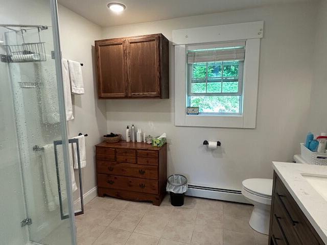 453 Canton Rd, Livermore, ME 04253 - full bathroom with baseboard heating, a shower stall, vanity, toilet, and tile patterned flooring