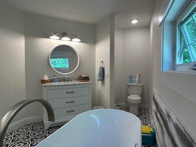 453 Canton Rd, Livermore, ME 04253 - full bath featuring a soaking tub, vanity, baseboards, and toilet